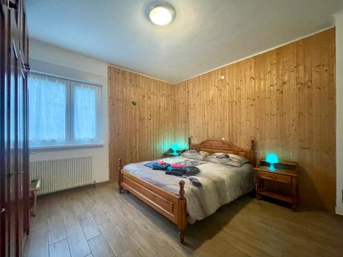 塔尔维西奥Maggioni Silvia的一间卧室配有一张带两个蓝色灯光的床