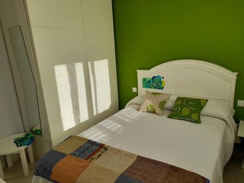 PolancoLa Boquerona的一间小卧室,配有白色的床和绿色的墙壁