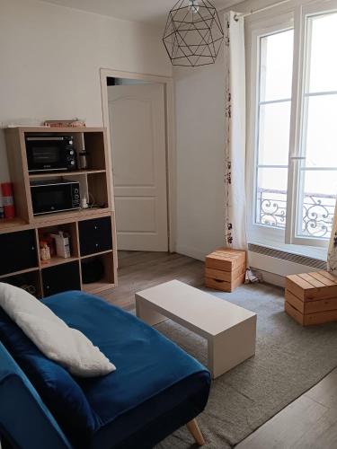 巴黎Appartement en plein coeur du 10eme et proche de plusieurs Gares的客厅配有蓝色的沙发和桌子