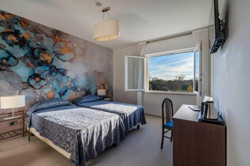 威尼斯丽都索瑞索酒店的卧室配有一张床,墙上挂有绘画作品