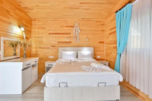契拉勒斯姆格旅馆的卧室配有白色的床和木墙