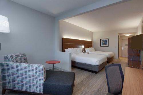 奥兰多奥兰多国际机场智选假日酒店的配有一张床和一把椅子的酒店客房