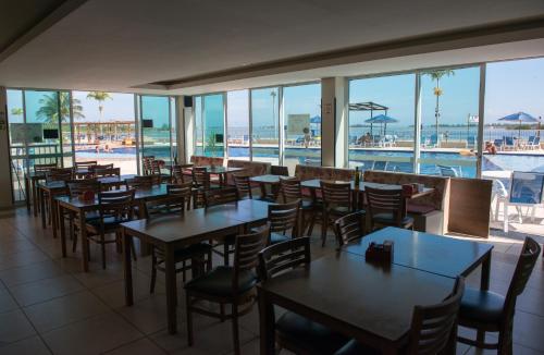 阿拉亚尔-杜卡布Arraial do Cabo - Condomínio com cara de Resort的一间带桌椅的餐厅和一个游泳池
