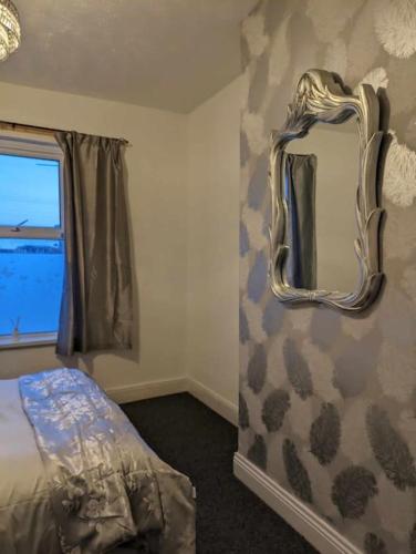 纽波特Cozy flat的一间卧室配有镜子、一张床和一个窗户