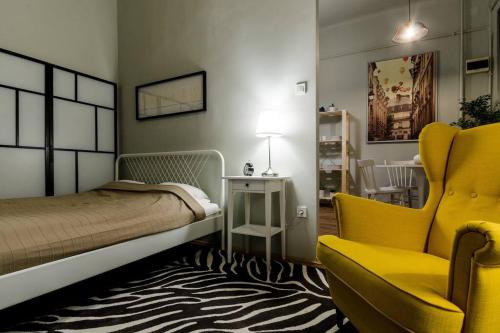布达佩斯Cosy Apartment In Party District K30的一间卧室配有一张床和一张黄色椅子