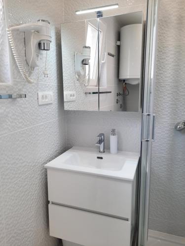 巴斯卡Apartments Alfa的白色的浴室设有水槽和镜子
