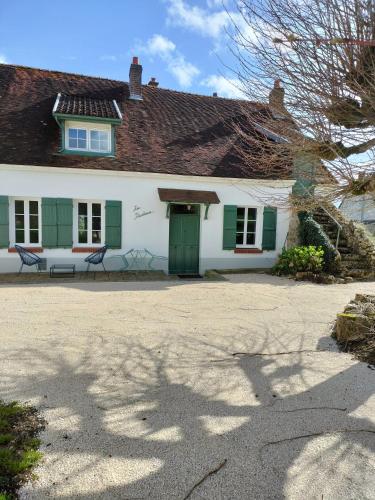 Mareuil-en-BrieCharmant gîte : Les flambeaux的白色的房子,有绿色百叶窗和绿色的门