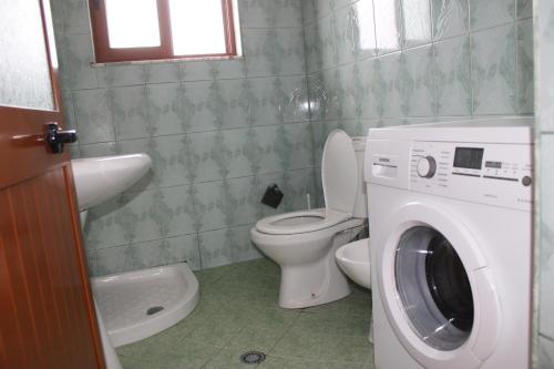 地拉那Haus Family Apartment的一间带卫生间和洗衣机的浴室