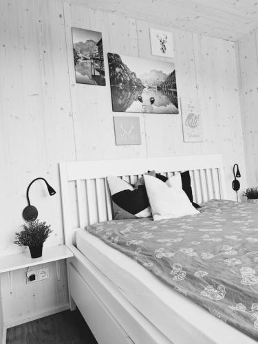 圣斯特凡Nature Living Koralm - Neue Chalets auf der Koralpe im Schi- und Wanderparadies的卧室配有一张床,墙上挂有图片