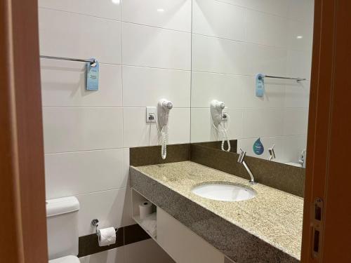 AraripinaNobile Hotel Araripina的一间带水槽和电话的浴室
