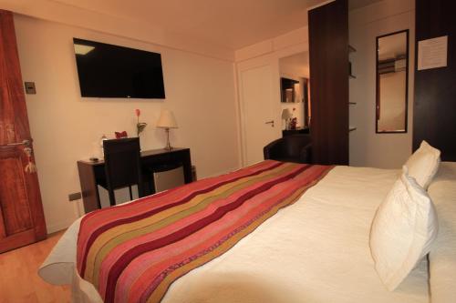 卡拉马阿坦卡拉马酒店的一间卧室配有一张带彩色毯子的床