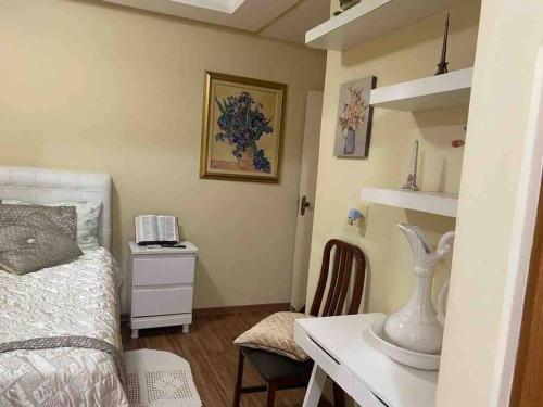 蒙蒂斯克拉鲁斯Apartamento Encantador C的一间卧室配有一张床和一张带电话的书桌