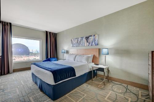 拉斯维加斯Spacious Retro 1 BR Condo with Sphere Views 1 Block from Vegas Strip NO Resort Fees的酒店客房设有床和窗户。