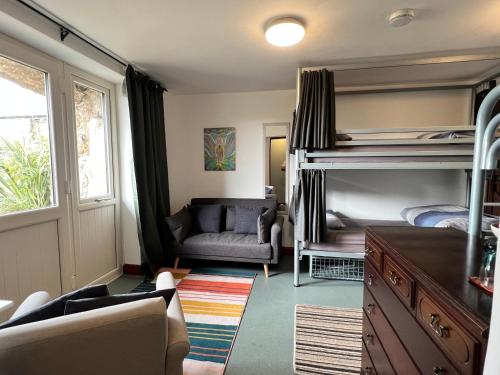 森嫩Lands End Hostel and B&B的一间卧室配有双层床、一张沙发和一把椅子