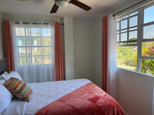 戴蒙德Faith's Villa Tobago的一间卧室设有一张床和两个窗户。