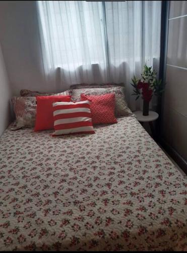马塞约Casa Aeroporto Maceió Palmeiras的卧室内的一张带红色和白色枕头的床