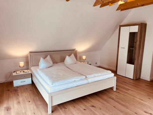 GarzFerienhaus Garz的卧室配有白色的床和镜子