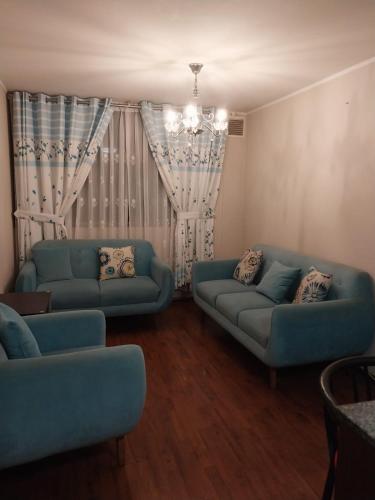 利马departamento de 1 dormitorio的客厅配有2张蓝色的沙发和窗户
