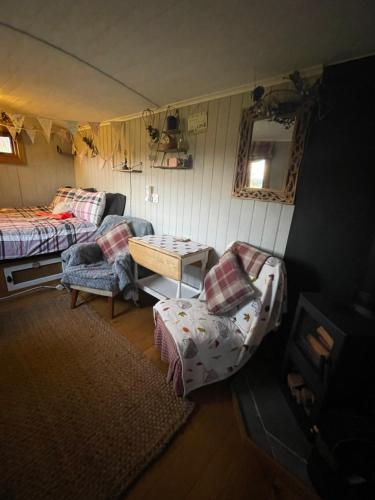 惠特比Oakley View Shepherds Hut with hot tub的帐篷内带一张床和一张桌子的房间