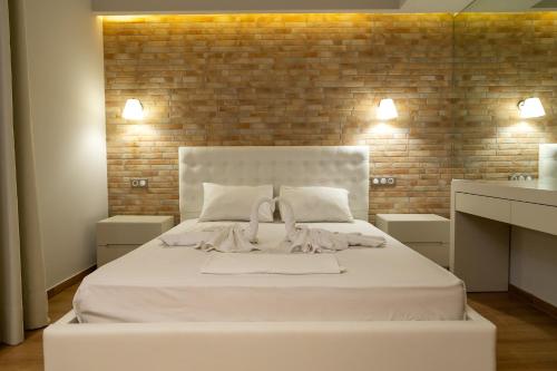 帕拉利亚卡泰里尼斯Aqua Mare Luxury Apartments的砖墙房间内的一张白色床