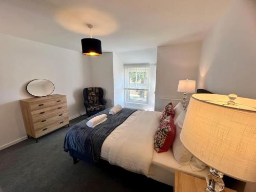 剑桥Lime Tree in blue Duplex Serviced Apartment的一间卧室配有一张床、一个梳妆台和一扇窗户。
