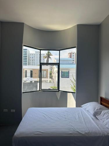 萨利纳斯Hotel Ipanema Beach by Majestic的一间卧室设有一张床和一个大窗户
