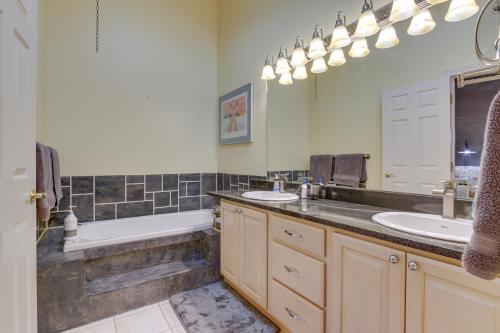 大瀑布城Inviting Great Falls Home with Wraparound Deck!的浴室配有两个盥洗盆、浴缸和浴缸。