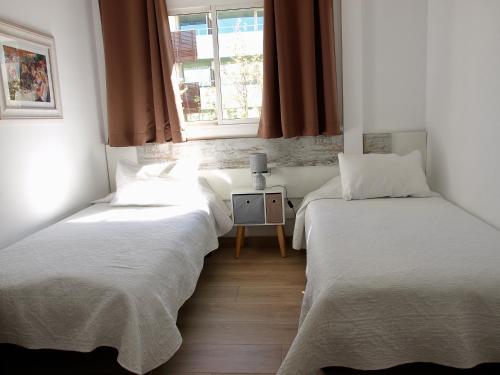 萨洛Dalt Vila Salou Deluxe的带窗户的客房内设有两张单人床。