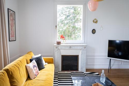 LeschesLA GRANDE MAISON LGM的客厅设有黄色沙发和壁炉