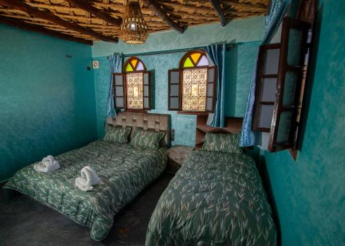 Aït AthmanePalma Ziz的一间卧室设有两张床和两个窗户。