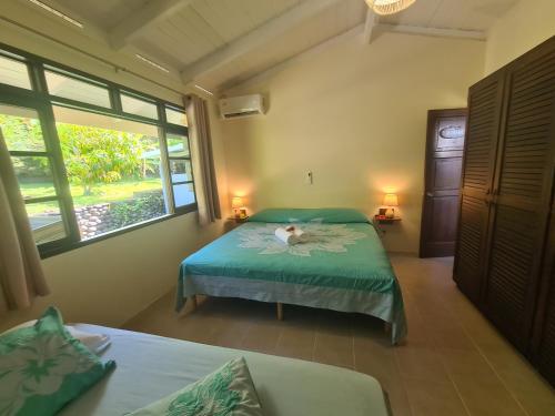 MahinaVilla MONOIHERE的一间卧室设有两张床和窗户。