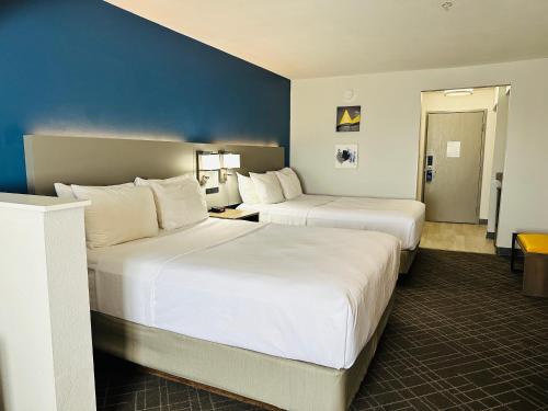 威斯敏斯特Comfort Suites Denver North - Westminster的酒店客房设有两张床和蓝色的墙壁。
