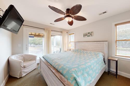科罗拉Beach Par Tee的一间卧室配有一张床和吊扇