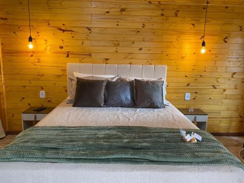 蒙特韦尔迪Chalés Canto da Serra的一间卧室配有一张带木墙的大床