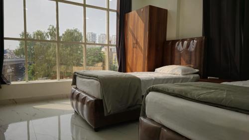 海得拉巴1BH with Pantry的一间卧室设有两张床和大窗户