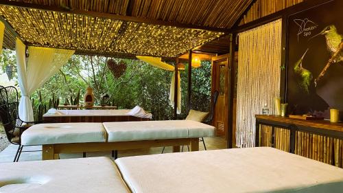 圣弗朗西斯科Natubri Ecohotel Habitacion VIP的一间带2张桌子和椅子的餐厅以及庭院