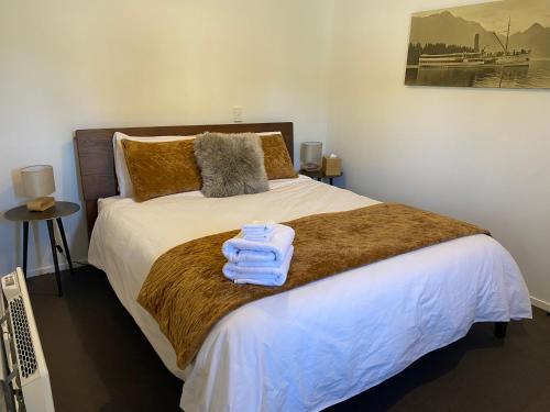格莱诺基Glenorchy Retreat Apartment的一间卧室配有带毛巾的床