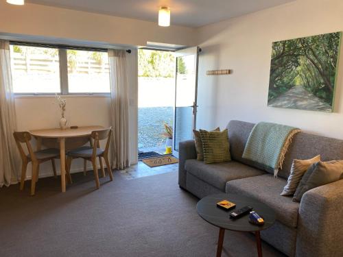格莱诺基Glenorchy Retreat Apartment的客厅配有沙发和桌子