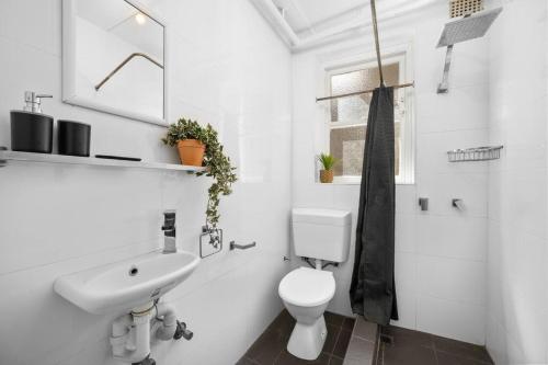 悉尼Urban retreat in Potts Point的白色的浴室设有水槽和卫生间。