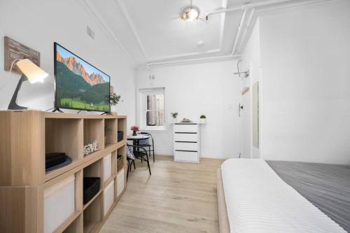 悉尼Urban retreat in Potts Point的白色卧室配有床和书桌