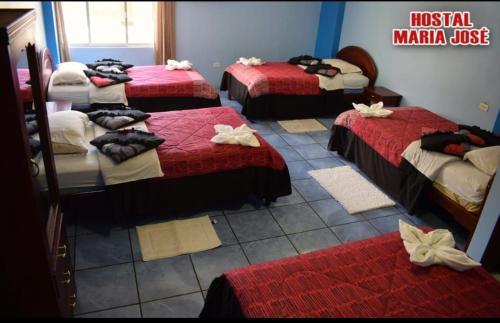 巴尼奥斯Hostal Maria José的一间设有4张红色和白色床单的房间
