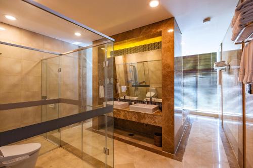 仁川市奥瑞卡松岛公园酒店的一间带玻璃淋浴和水槽的浴室