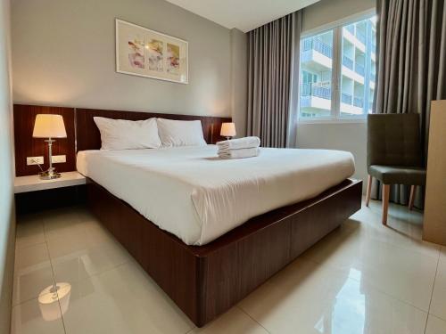 Ban Khlong HaengHidayah Condotel,Ao-nang, Krabi的卧室配有床、椅子和窗户。