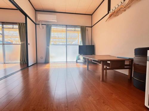 AmakusaLit 天草的客厅配有桌子,铺有木地板