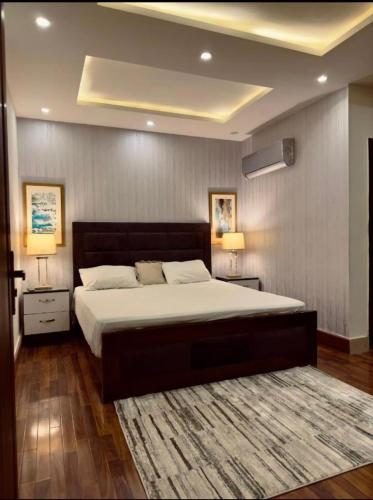 沙迦1 bed apartment available in Al nadd的一间卧室配有一张大床,设有两个床头柜和两盏灯