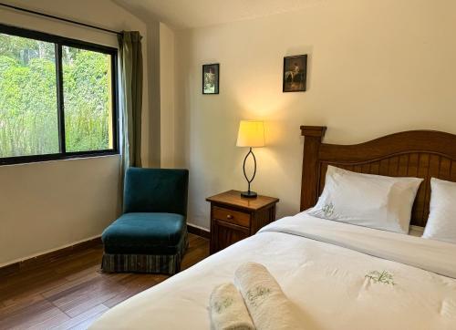 YaruguíMckay's Quinta的卧室配有床、椅子和窗户。