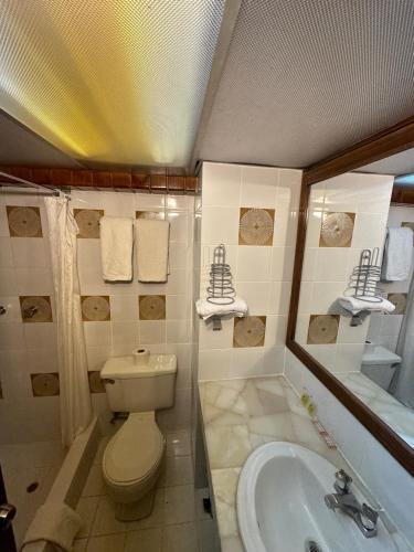 昆卡Hotel Presidente by NASS的浴室配有卫生间、盥洗盆和浴缸。