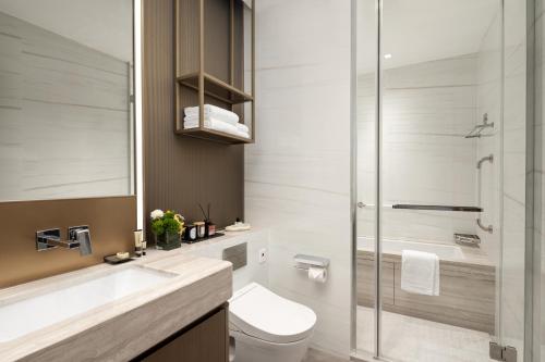 广州广州雅诗阁琶洲服务公寓的一间带卫生间和玻璃淋浴间的浴室