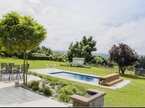 特镇Spacious villa with private pool in Theux的后院设有游泳池、桌子和椅子
