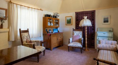 MarrangarooFernbrook Cottage的客厅配有桌椅和台灯